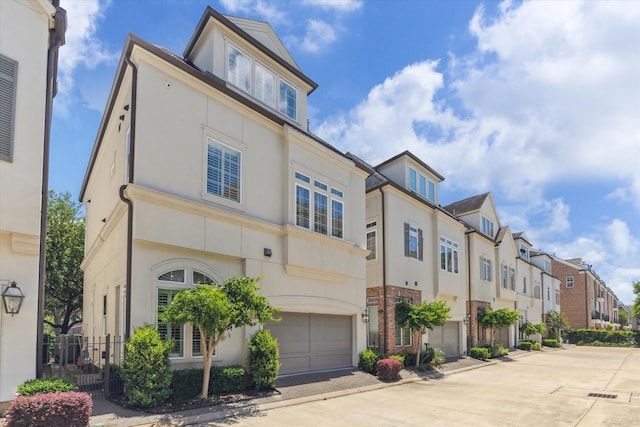 1206 Lake Pointe Pkwy, Sugar Land, TX 77478 - view of front facade with a residential view, a garage, stucco siding, and concrete driveway