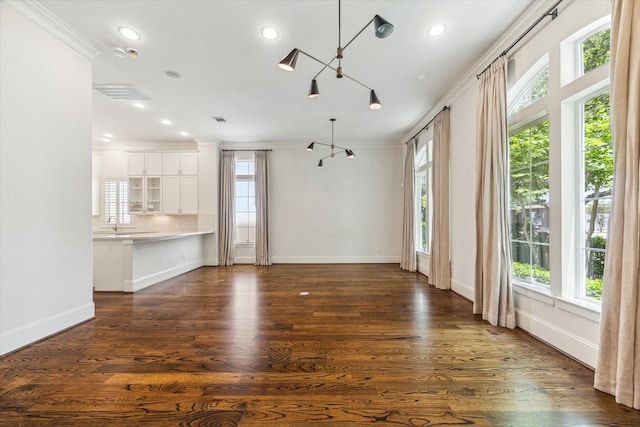 1206 Lake Pointe Pkwy, Sugar Land, TX 77478 - unfurnished living room featuring a chandelier, plenty of natural light, crown molding, baseboards, and recessed lighting
