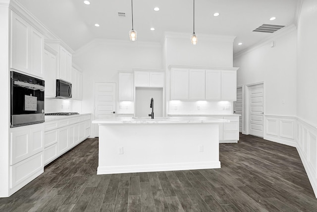 400 Little Spring Ct, Anahuac, TX 77514 - kitchen with oven, ornamental molding, stainless steel microwave, a kitchen island with sink, and stovetop
