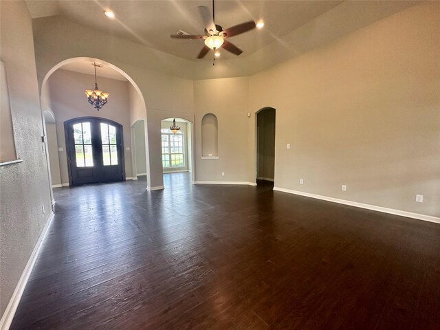 305 Tyler Dr, Bridge City, TX 77630 - unfurnished living room with arched walkways, a ceiling fan, baseboards, dark wood-style flooring, and a high ceiling
