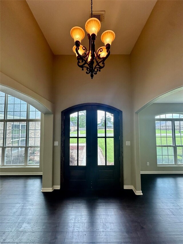 305 Tyler Dr, Bridge City, TX 77630 - foyer entrance with a chandelier, arched walkways, dark wood-style floors, a high ceiling, and french doors