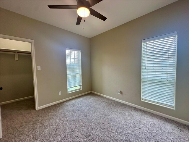 305 Tyler Dr, Bridge City, TX 77630 - unfurnished bedroom with a walk in closet, carpet, baseboards, vaulted ceiling, and a closet