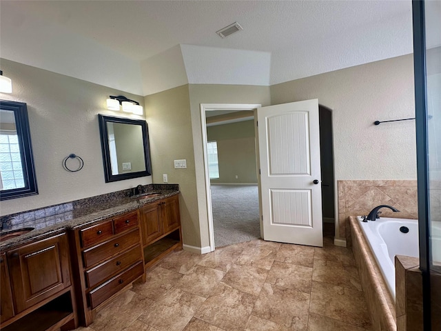 305 Tyler Dr, Bridge City, TX 77630 - full bathroom with double vanity, a garden tub, baseboards, and vaulted ceiling