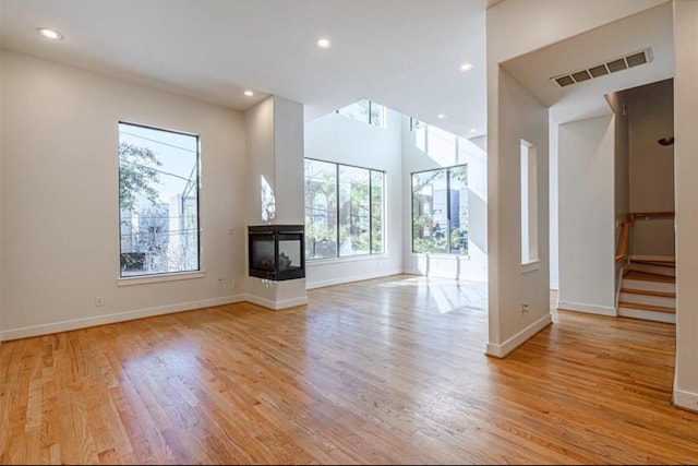 730 Ruthven, Houston, TX 77019 - unfurnished living room featuring healthy amount of natural light, light wood finished floors, baseboards, and recessed lighting