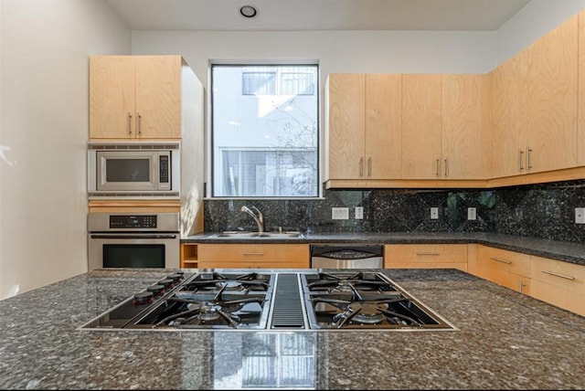 730 Ruthven, Houston, TX 77019 - kitchen with stainless steel appliances, a sink, light brown cabinets, tasteful backsplash, and dark stone countertops