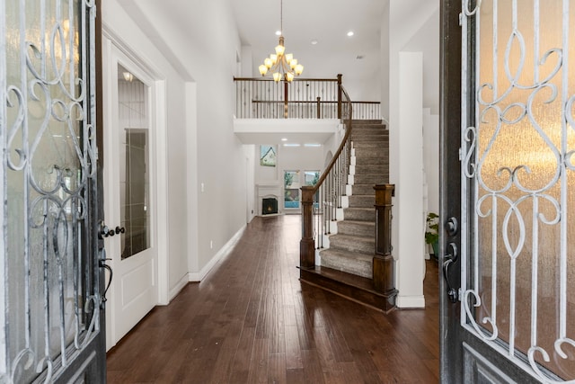 foyer entrance featuring a chandelier, stairs, dark wood-style floors, baseboards, and recessed lighting