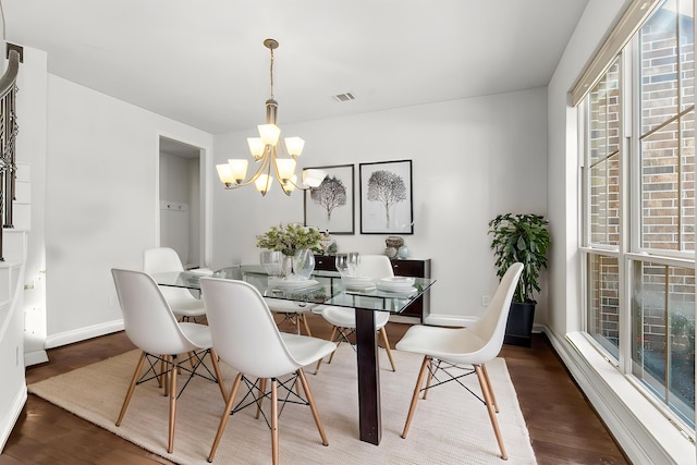 dining room featuring a chandelier, wood finished floors, and baseboards