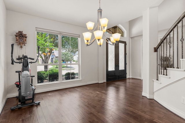 entryway featuring french doors, stairs, a chandelier, and baseboards