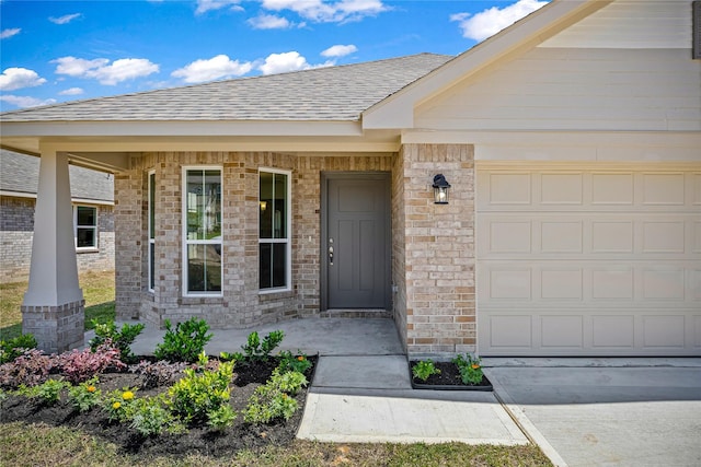 20068 Swinley Forest Dr, Cleveland, TX 77327 - property entrance featuring an attached garage, roof with shingles, concrete driveway, and brick siding