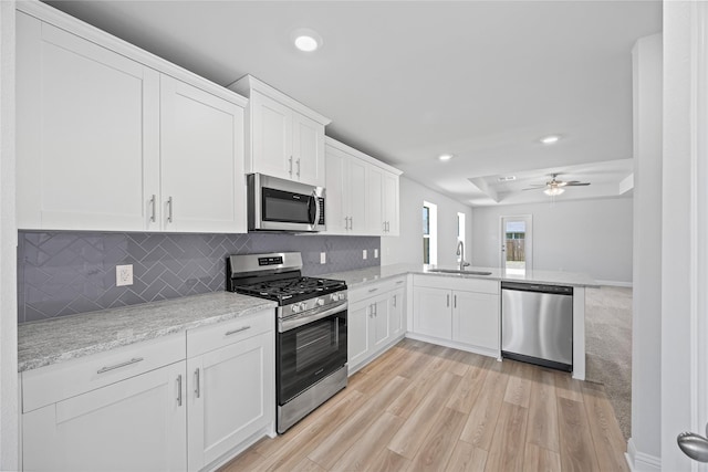 20068 Swinley Forest Dr, Cleveland, TX 77327 - kitchen with stainless steel appliances, a sink, decorative backsplash, white cabinetry, and recessed lighting