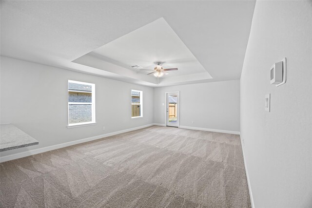 20068 Swinley Forest Dr, Cleveland, TX 77327 - carpeted empty room with a tray ceiling, ceiling fan, and baseboards