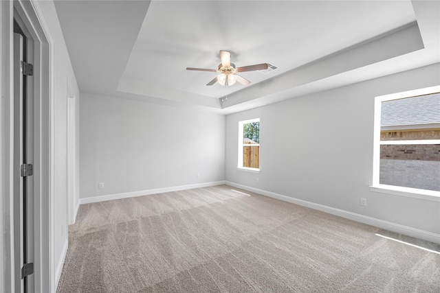 20068 Swinley Forest Dr, Cleveland, TX 77327 - spare room with a tray ceiling, carpet, ceiling fan, and baseboards