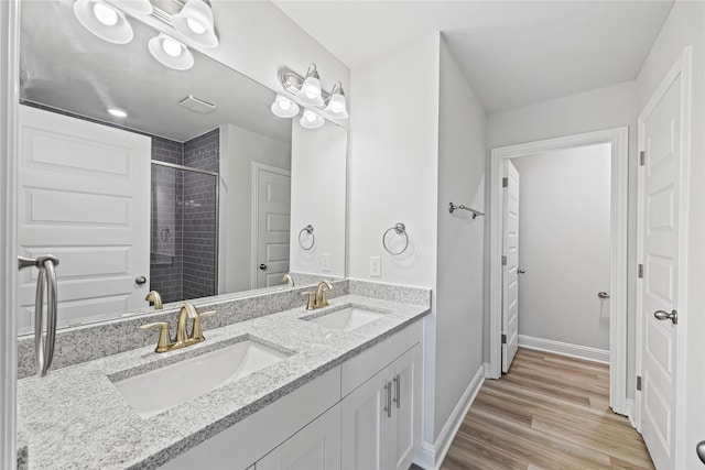 20068 Swinley Forest Dr, Cleveland, TX 77327 - bathroom with a stall shower, double vanity, wood finished floors, and baseboards