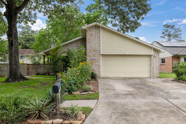 view of front of house with brick siding, concrete driveway, a garage, and fence