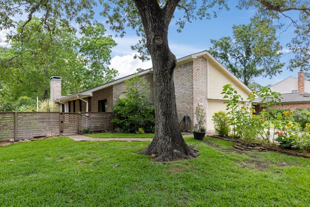 view of home's exterior featuring a gate, a chimney, brick siding, and a garage