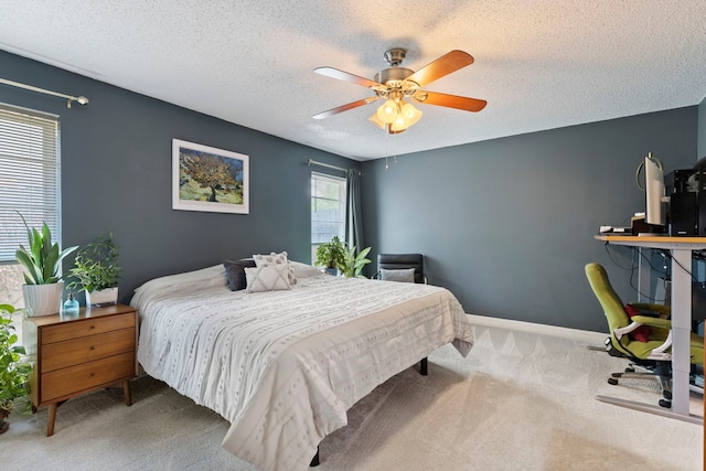 carpeted bedroom featuring a textured ceiling, ceiling fan, and baseboards