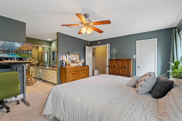 bedroom featuring a sink, light colored carpet, ensuite bath, a textured ceiling, and a ceiling fan