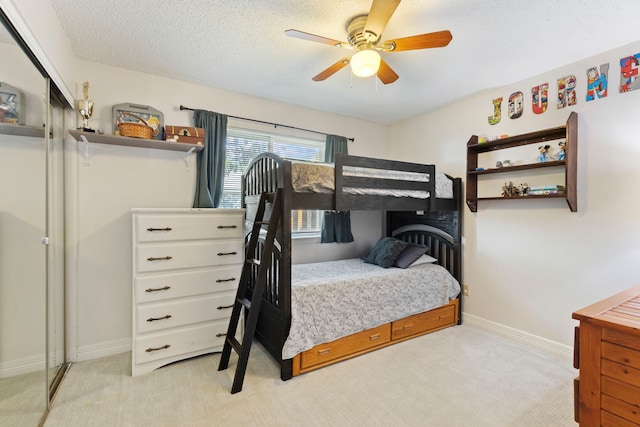 bedroom featuring carpet flooring, baseboards, ceiling fan, and a textured ceiling