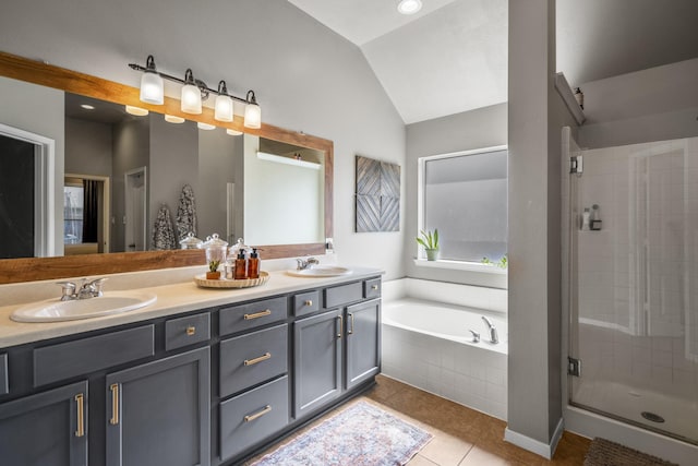 full bath with a stall shower, vaulted ceiling, tile patterned flooring, a bath, and double vanity