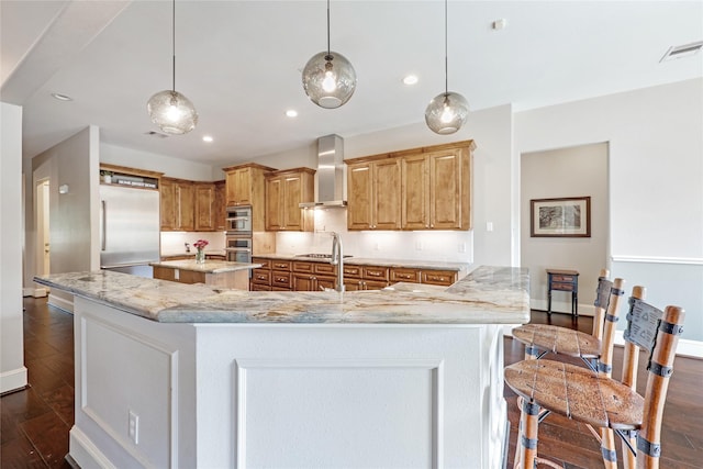5523 Harvest Oak Landing Dr, Spring, TX 77386 - kitchen with wall chimney range hood, stainless steel appliances, dark wood-type flooring, a large island, and recessed lighting