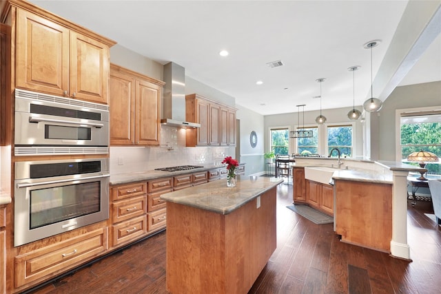 5523 Harvest Oak Landing Dr, Spring, TX 77386 - kitchen with wall chimney range hood, a center island with sink, a sink, gas cooktop, and plenty of natural light