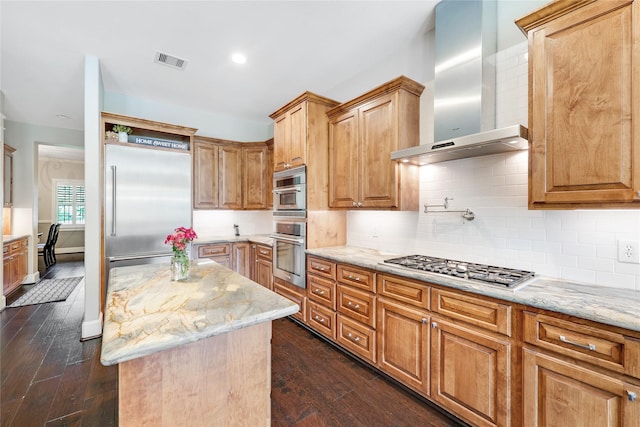 5523 Harvest Oak Landing Dr, Spring, TX 77386 - kitchen featuring appliances with stainless steel finishes, wall chimney exhaust hood, light stone counters, dark wood finished floors, and recessed lighting