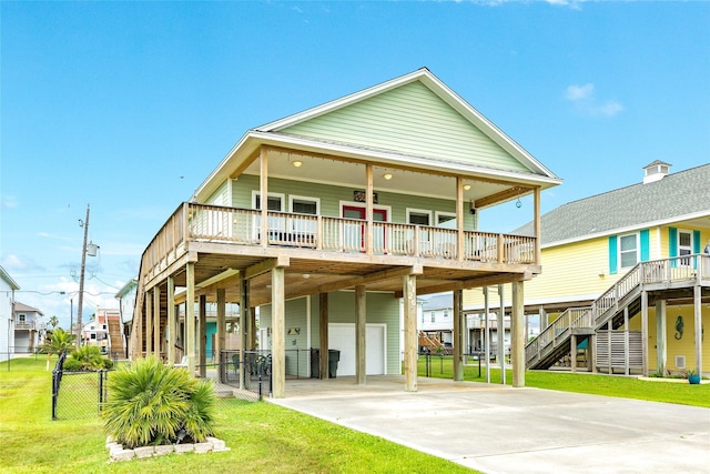 4126 Grayson Dr, Galveston, TX 77554 - rear view of house with a carport, an attached garage, driveway, stairs, and a wooden deck