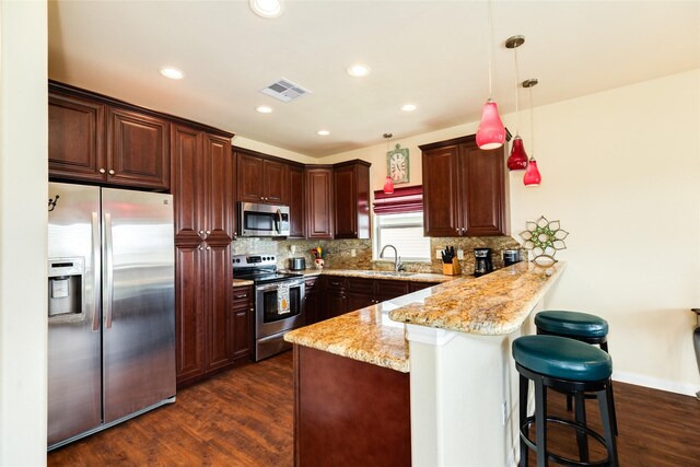4126 Grayson Dr, Galveston, TX 77554 - kitchen featuring stainless steel appliances, a peninsula, dark wood-style floors, backsplash, and recessed lighting