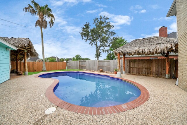 view of swimming pool with a fenced backyard and a gazebo