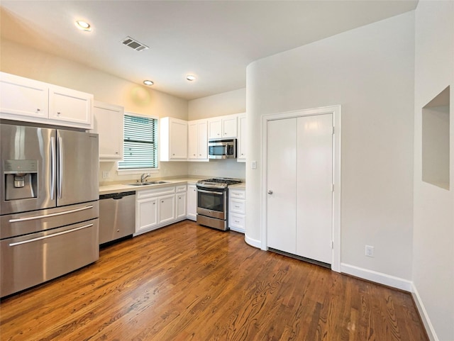 3701 Main Plaza Dr, Houston, TX 77025 - kitchen with stainless steel appliances, white cabinets, dark wood-style floors, light countertops, and a sink