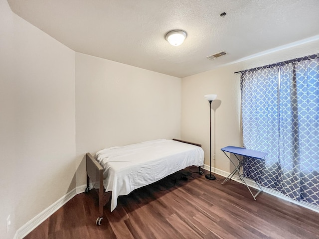 5715 Ladonia St, Arcola, TX 77583 - bedroom with wood finished floors, baseboards, and a textured ceiling