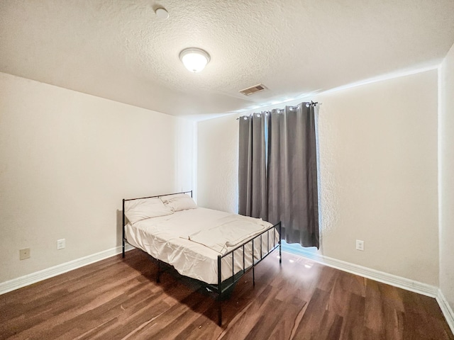 5715 Ladonia St, Arcola, TX 77583 - bedroom with wood finished floors, a textured ceiling, and baseboards
