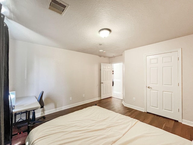 5715 Ladonia St, Arcola, TX 77583 - bedroom with dark wood-style floors, baseboards, a textured ceiling, and a desk