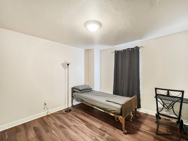 5715 Ladonia St, Arcola, TX 77583 - bedroom with wood finished floors, baseboards, and a textured ceiling
