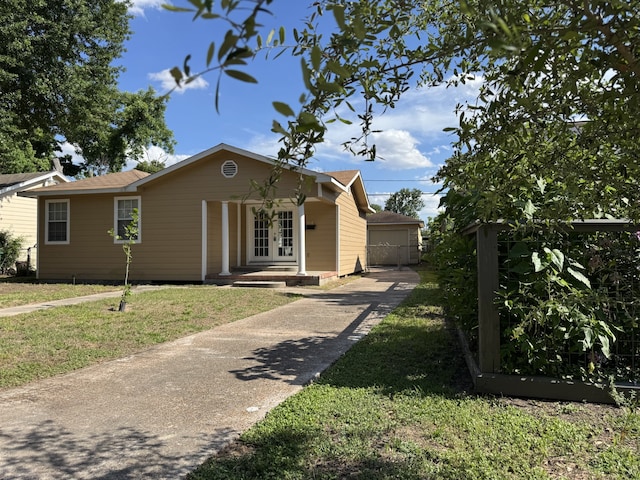 216 Gale St, Houston, TX 77009 - ranch-style home featuring french doors, a front yard, and an outbuilding