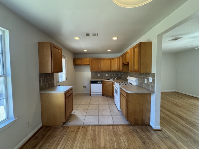 216 Gale St, Houston, TX 77009 - kitchen with white appliances, a sink, brown cabinets, baseboards, and light wood-style flooring