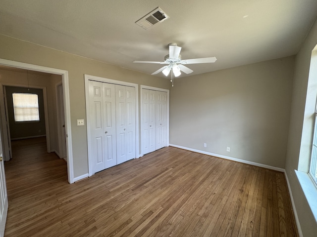 216 Gale St, Houston, TX 77009 - unfurnished bedroom featuring wood finished floors, two closets, and baseboards