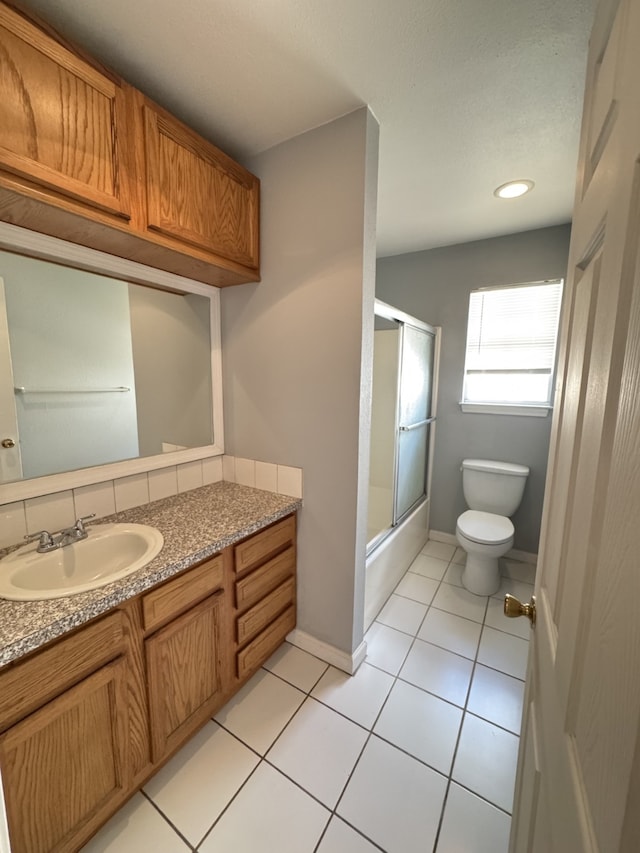 216 Gale St, Houston, TX 77009 - bathroom with toilet, vanity, tile patterned flooring, bath / shower combo with glass door, and baseboards
