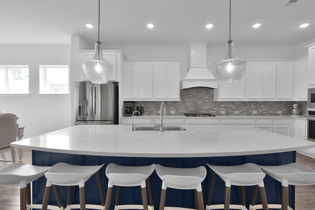 2807 Kingly Pine Trl, Conroe, TX 77385 - kitchen featuring appliances with stainless steel finishes, a sink, custom range hood, decorative backsplash, and light countertops