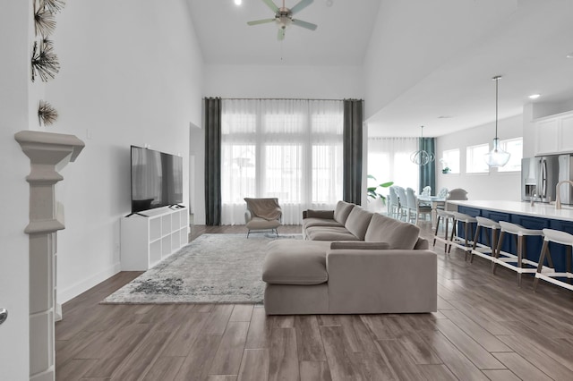 2807 Kingly Pine Trl, Conroe, TX 77385 - living room with high vaulted ceiling, a ceiling fan, dark wood-style floors, and baseboards