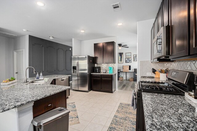 10906 Granite Chief Dr, Rosharon, TX 77583 - kitchen featuring a sink, stainless steel appliances, light stone counters, tasteful backsplash, and light tile patterned flooring