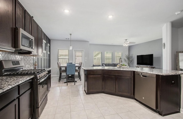 10906 Granite Chief Dr, Rosharon, TX 77583 - kitchen with stainless steel appliances, a sink, a ceiling fan, open floor plan, and dark brown cabinets