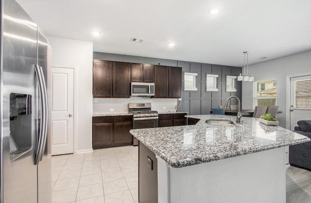 10906 Granite Chief Dr, Rosharon, TX 77583 - kitchen featuring stainless steel appliances, a sink, dark brown cabinets, light stone countertops, and recessed lighting
