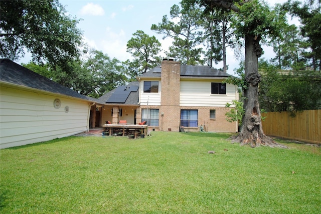 15007 Pebble Bend Dr, Houston, TX 77068 - rear view of property with roof mounted solar panels, a chimney, and brick siding