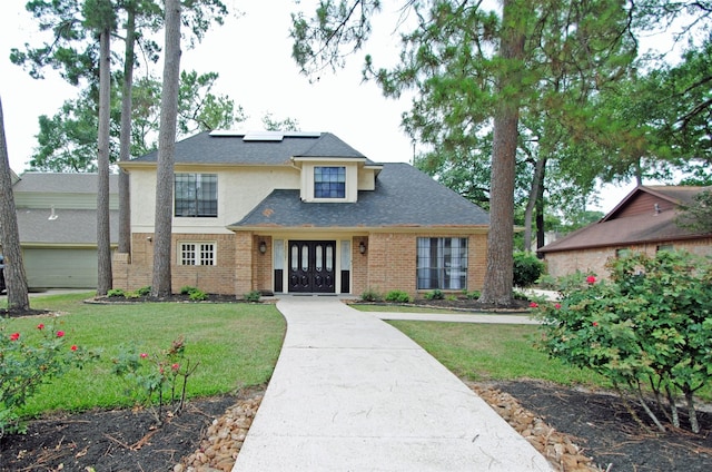 15007 Pebble Bend Dr, Houston, TX 77068 - traditional-style home featuring a front yard, french doors, stucco siding, and solar panels