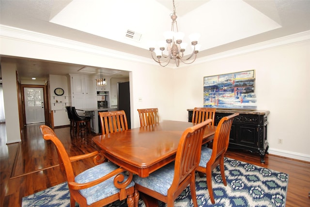 15007 Pebble Bend Dr, Houston, TX 77068 - dining area with a chandelier, wood finished floors, a tray ceiling, baseboards, and crown molding