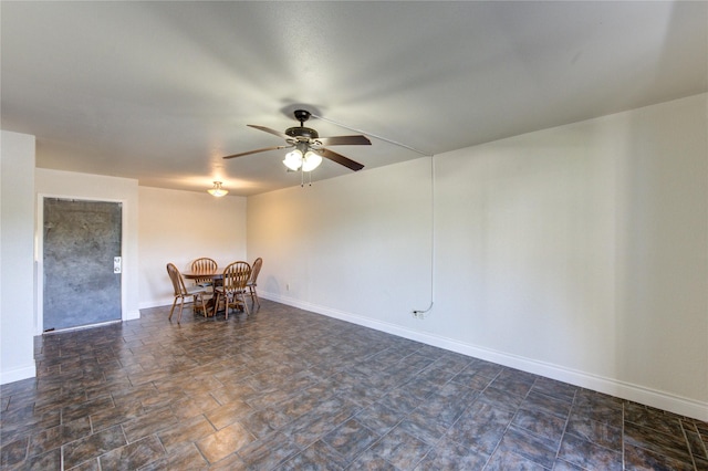 unfurnished dining area featuring a ceiling fan and baseboards