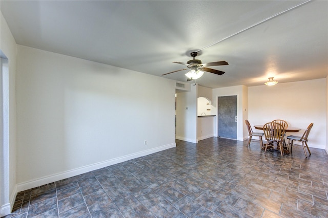 dining space featuring ceiling fan and baseboards