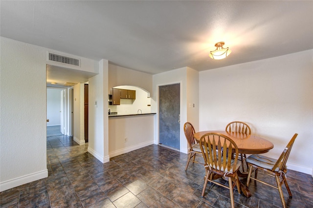 dining area featuring arched walkways and baseboards