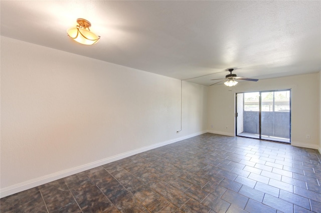 empty room featuring ceiling fan and baseboards